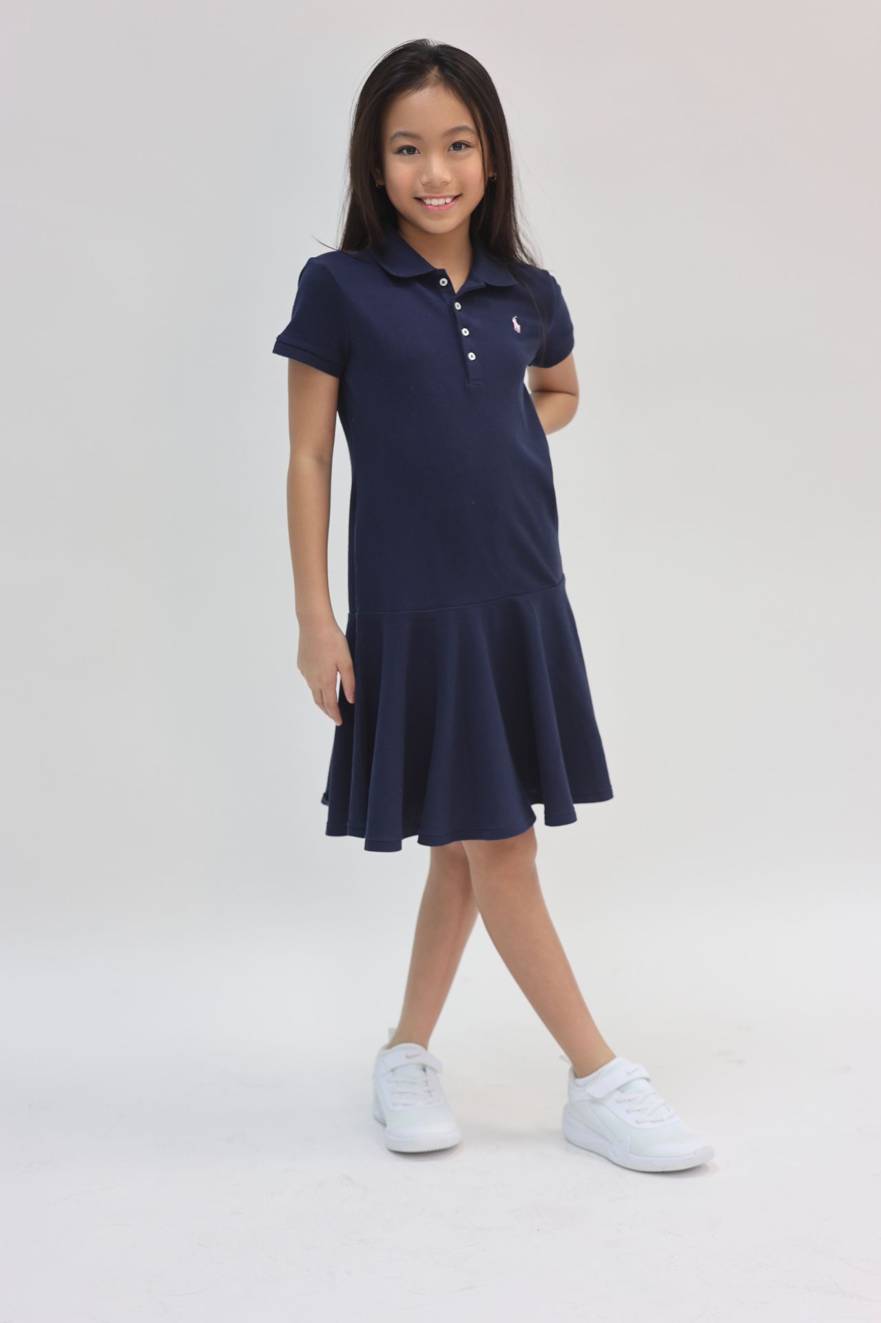 Navy polo drop-waist dress with white sneakers, full-length smile