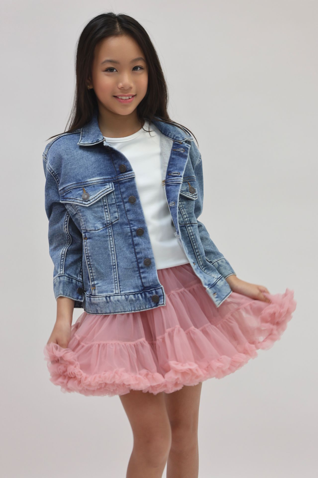 Denim jacket and pink tulle skirt three-quarter portrait