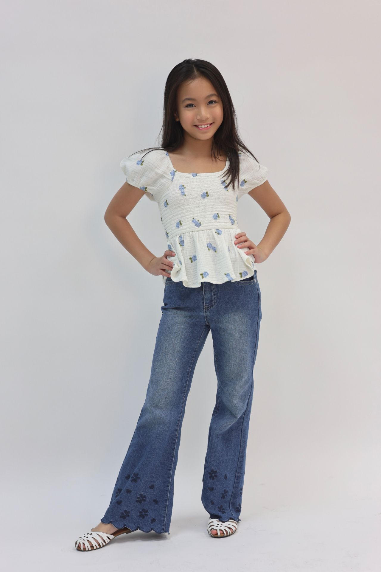 Commercial editorial pose in floral peplum top and denim