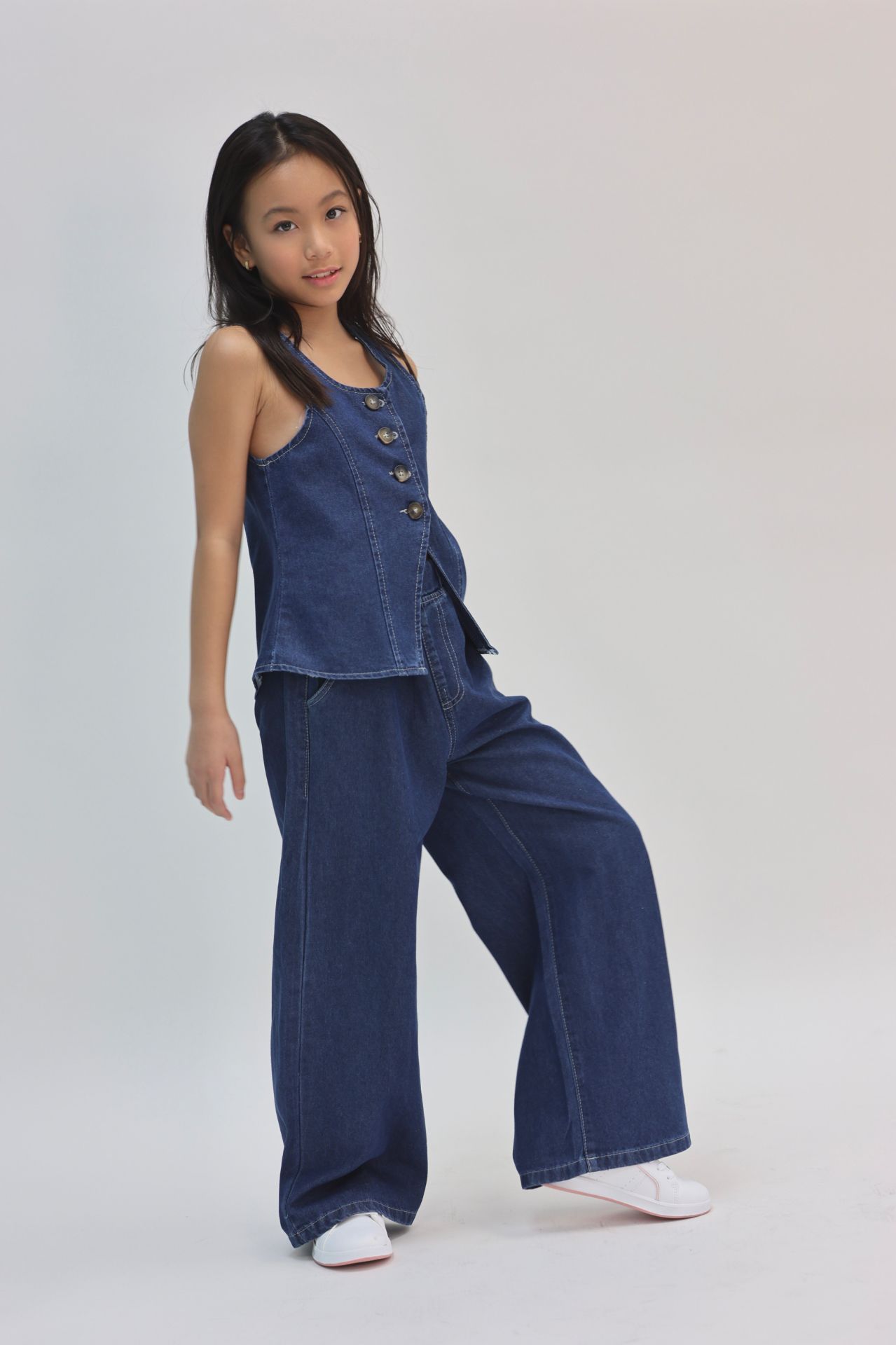 Denim vest and wide-leg jeans studio portrait
