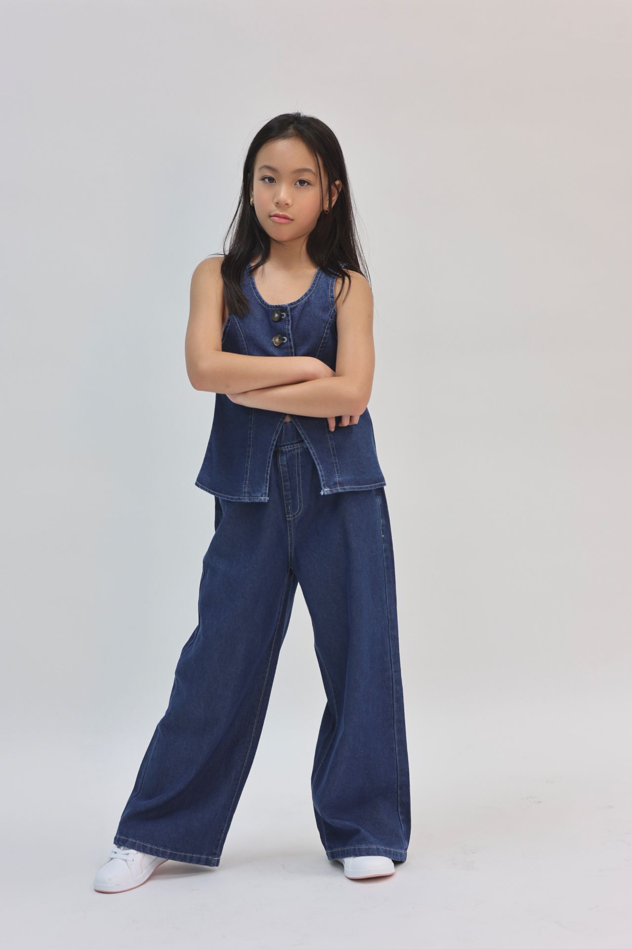 Denim two-piece crossed-arms studio pose