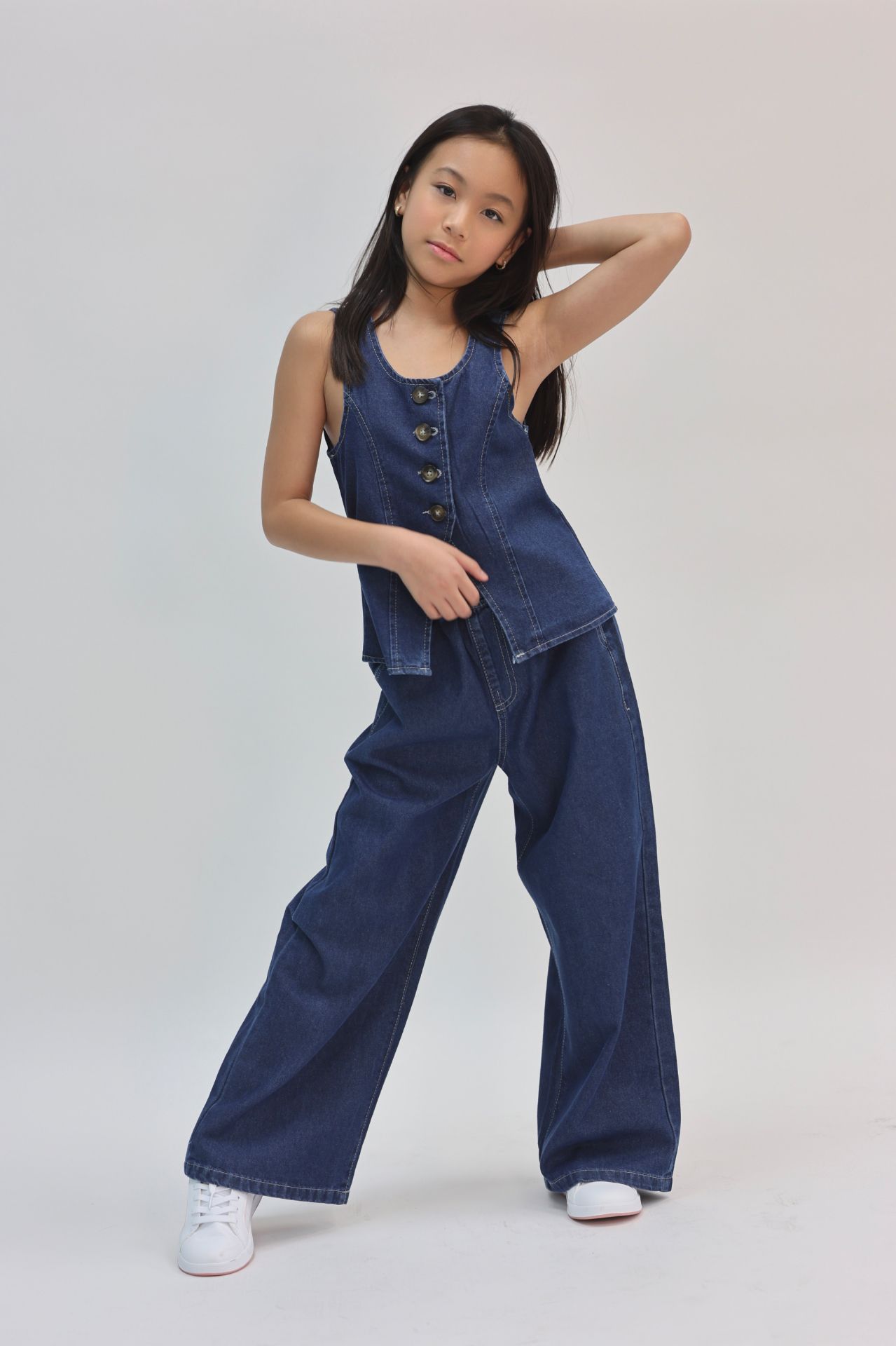 Denim vest and wide-leg jeans editorial pose