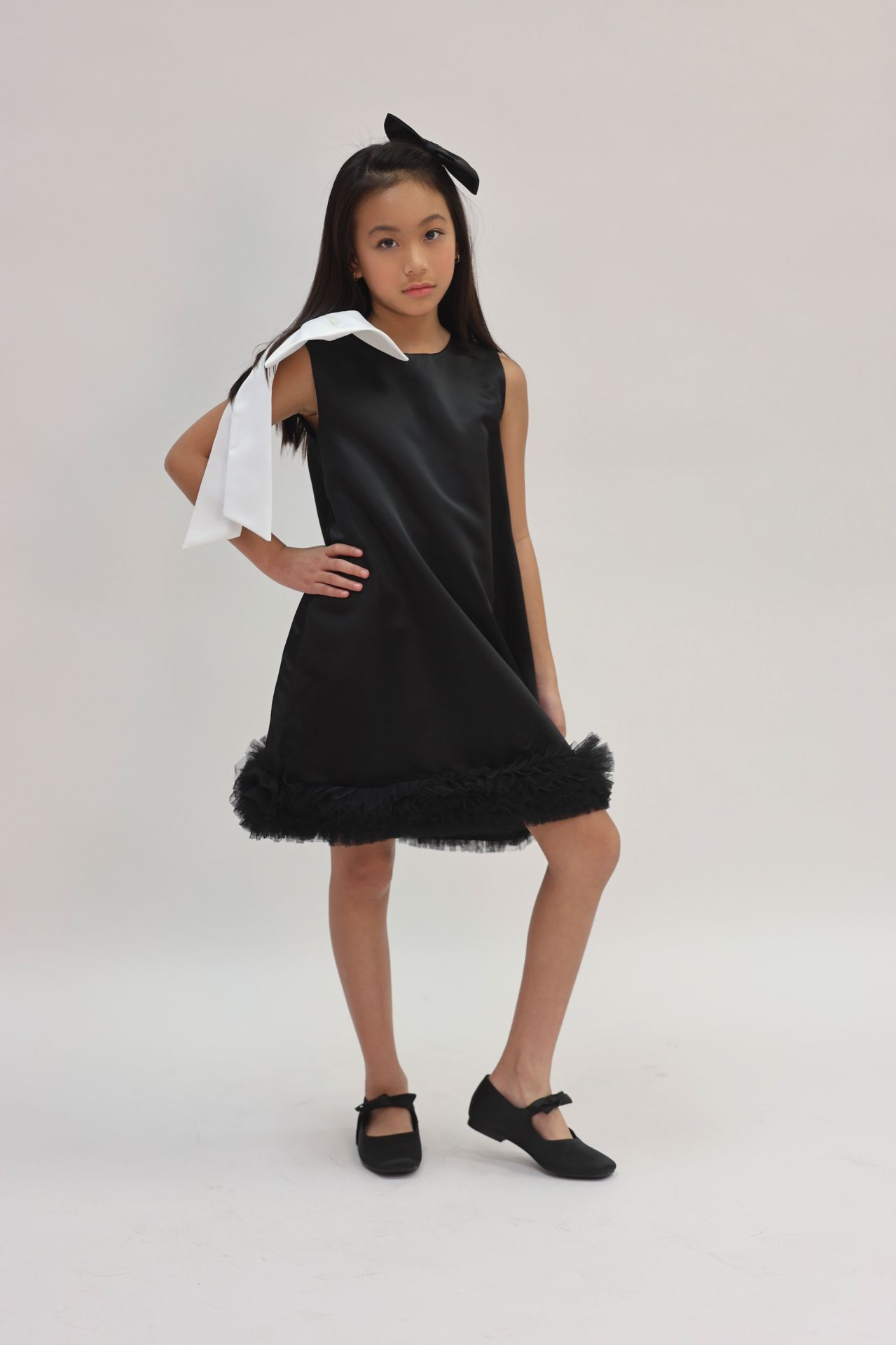Editorial pose in black satin shift dress, hand on hip