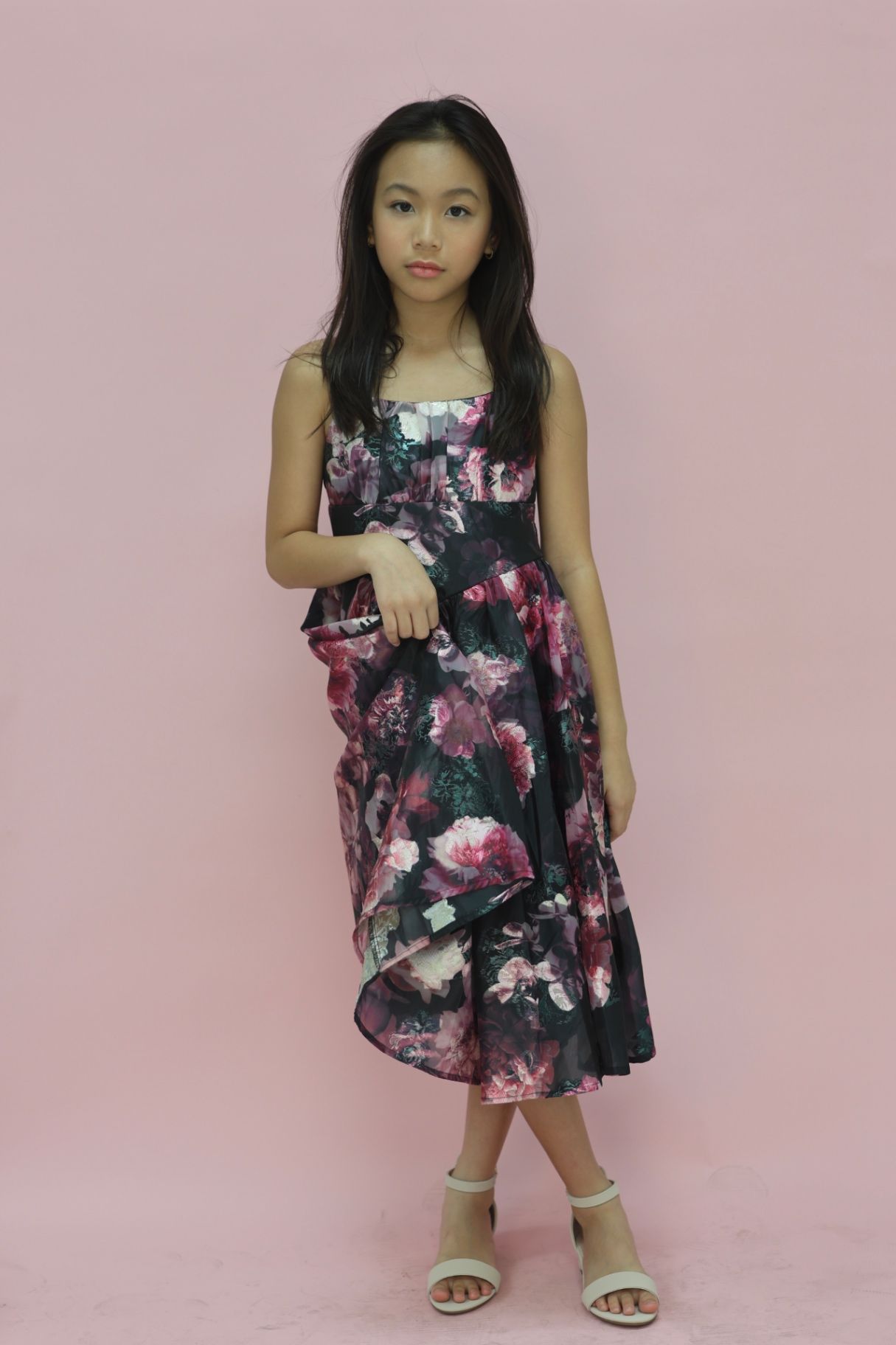 Full-length editorial in floral organza dress on pink backdrop